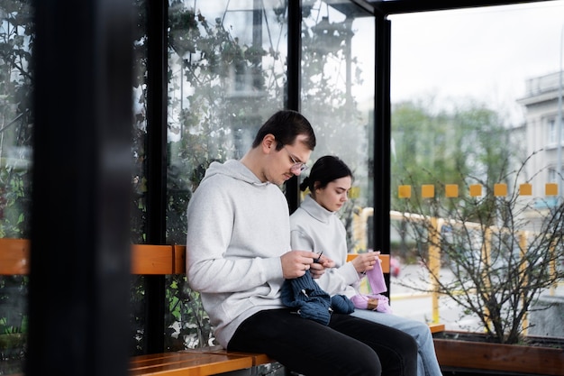 Young adults knitting outside