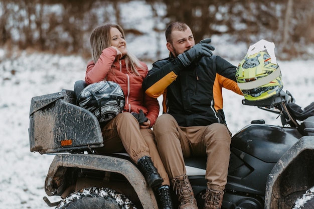 A young adventurous couple embraces the joy of love and thrill as they ride an atv quad through the
