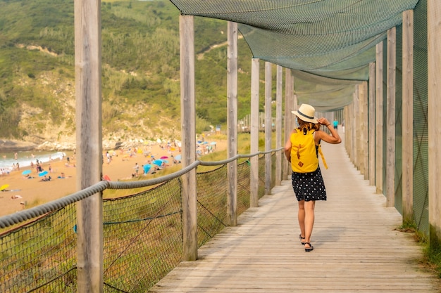 Young and adventurous girl enjoying summer vacation walking alone along the beach