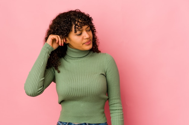 Young african american afro woman isolated covering ears with fingers, stressed and desperate by a loudly ambient.