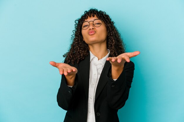 La giovane donna afroamericana afro ha isolato le labbra pieganti e le palme della holding per inviare il bacio dell'aria.