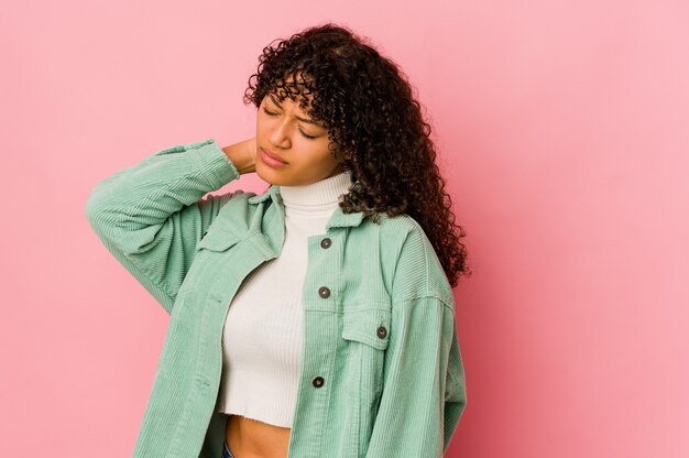 Young african american afro woman isolated having a neck pain due to stress, massaging and touching it with hand.