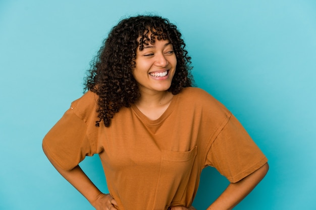 Young african american afro woman isolated laughs and closes eyes, feels relaxed and happy.