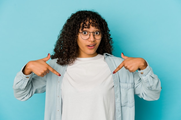 Photo young african american afro woman isolated points down with fingers, positive feeling.