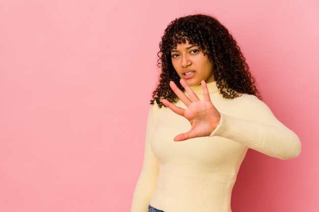 Young african american afro woman isolated rejecting someone showing a gesture of disgust.