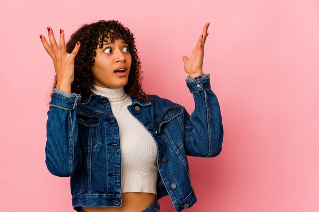 Giovane donna afroamericana afro isolata che grida al cielo, alzando lo sguardo, frustrato.