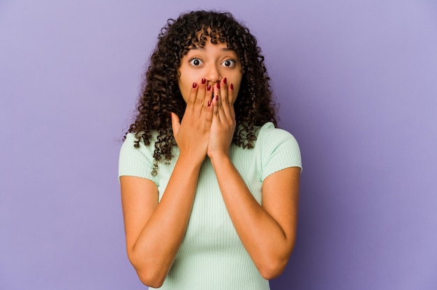 Young african american afro woman isolated shocked, covering mouth with hands, anxious to discover something new.