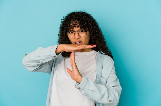 Young african american afro woman isolated showing a timeout gesture.