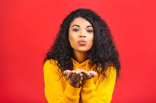 young african american black woman sending air kiss isolated over red background