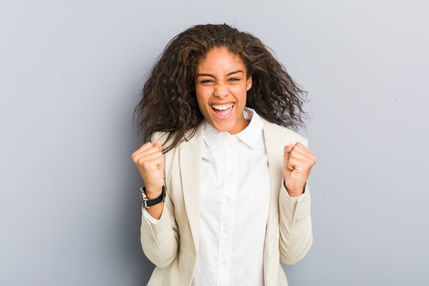 Young african american business woman cheering carefree and excited