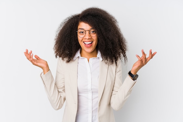 Young african american business woman receiving a pleasant surprise, excited and raising hands.