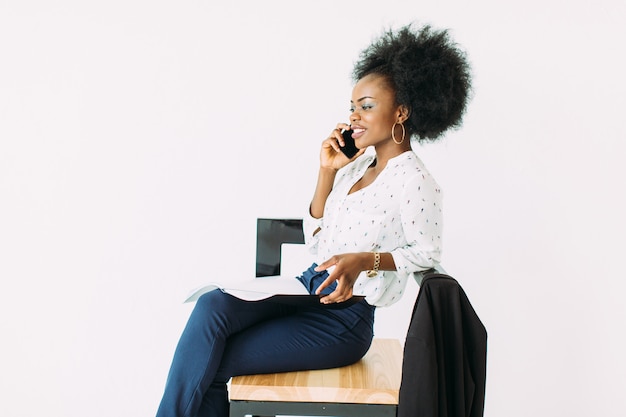 Young african american business woman talking on the phone while sitting on the chair