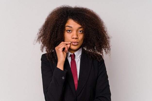 Young African American business woman wearing a suit isolated on white with fingers on lips keeping a secret.