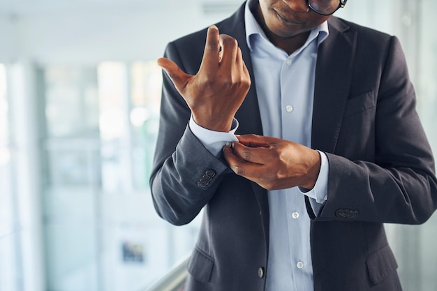 Young african american businessman in black suit is indoors