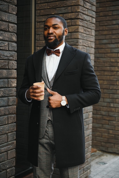 Young african american businessman drinking take away coffee at the city