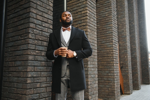 Young african american businessman drinking take away coffee at the city