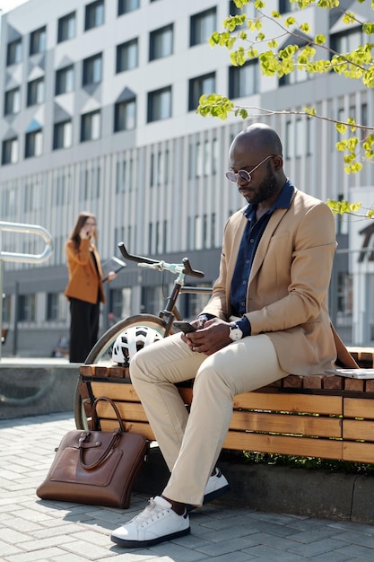 young african american businessman scrolling in smartphone