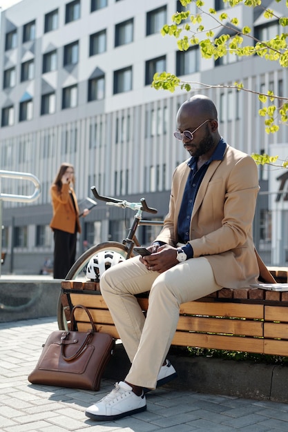 Young african american businessman scrolling in smartphone