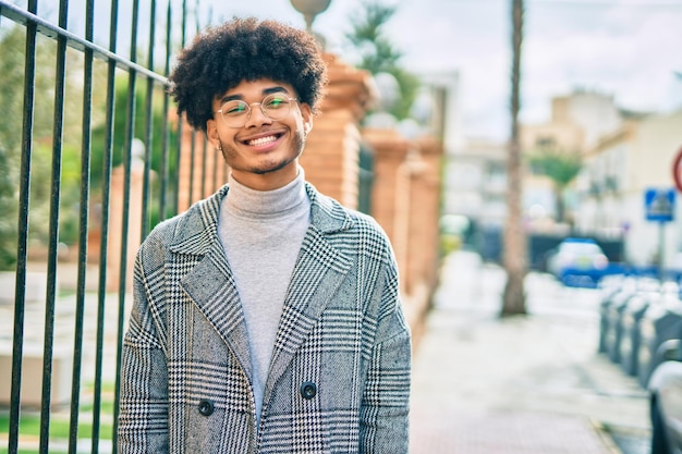 Young african american businessman smiling happy standing at the city