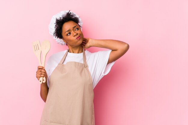 Young african american cook woman touching back of head, thinking and making a choice.