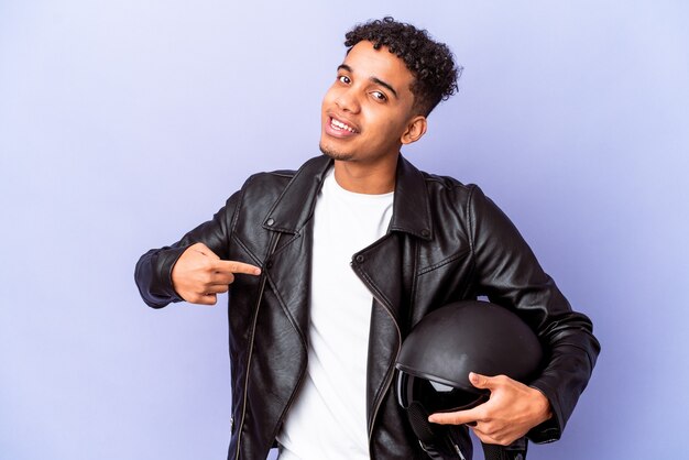 Young african american curly biker man isolated person pointing by hand to a shirt copy space, proud and confident