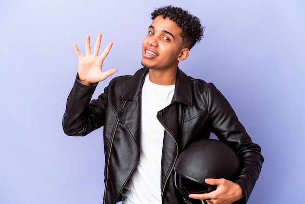 Young african american curly biker man isolated smiling cheerful showing number five with fingers.