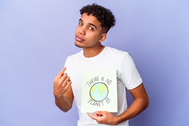 Молодой афро-американский кудрявый мужчина изолирован с плакатом Theres is is Not Planet b, указывая пальцем на вас, как будто приглашая подойти ближе.