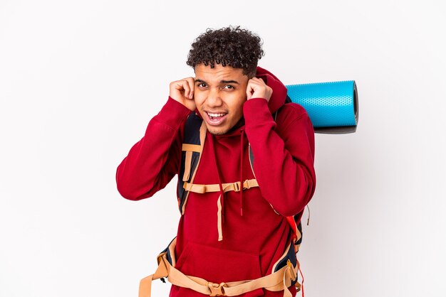 Young african american curly traveler man isolated covering ears with hands.