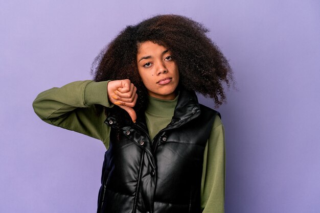 Photo young african american curly woman isolated on purple wall showing a dislike gesture, thumbs down. disagreement concept.