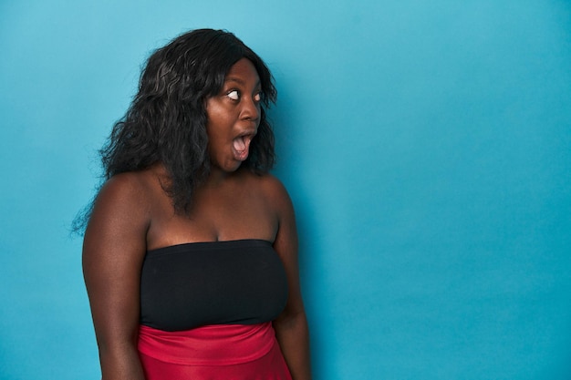 Young african american curvy woman being shocked because of something she has seen