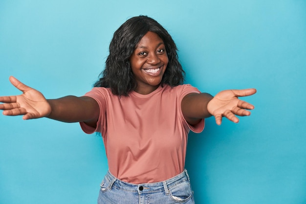 Young african american curvy woman feels confident giving a hug to the camera