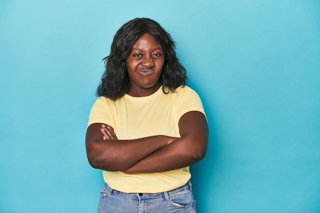 Young african american curvy woman frowning face in displeasure keeps arms folded