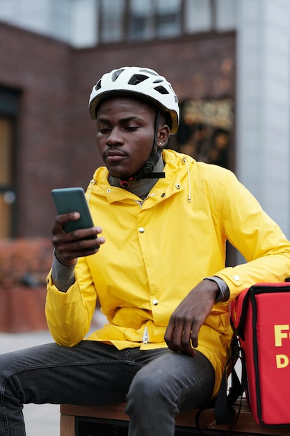 Young african american delivery man in helmet and uniform