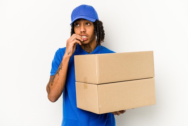 Young African American delivery man isolated on white background relaxed thinking about something looking at a copy space