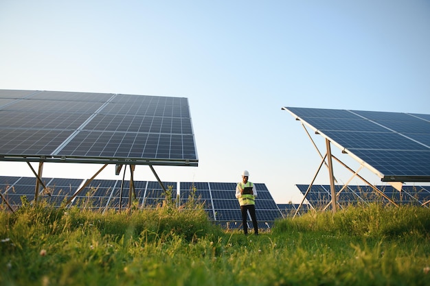 Young African American engineer in a field of solar panels