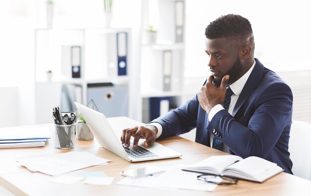 Photo young african american entrepreneur studying competitors online