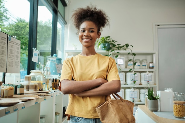 a young african american female customer with a reusable bag in a refill store