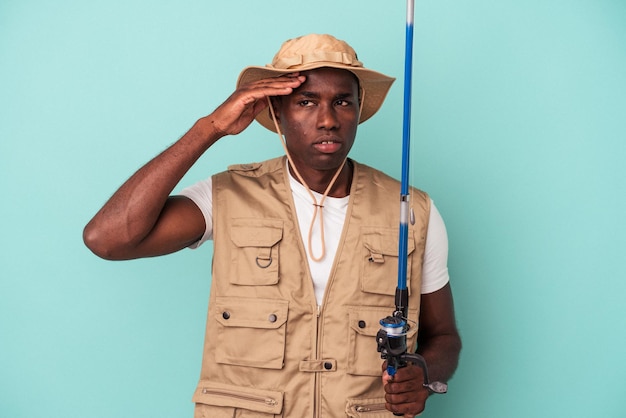 Young African American fisherman holding rod isolated on blue background being shocked, she has remembered important meeting.