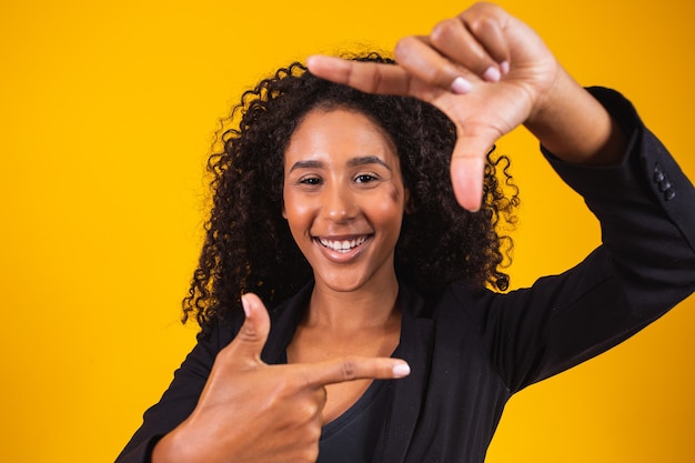 Young african american girl wearing executive clothes smiling making photo frame with hands and fingers with a happy face. creativity and photography concept.