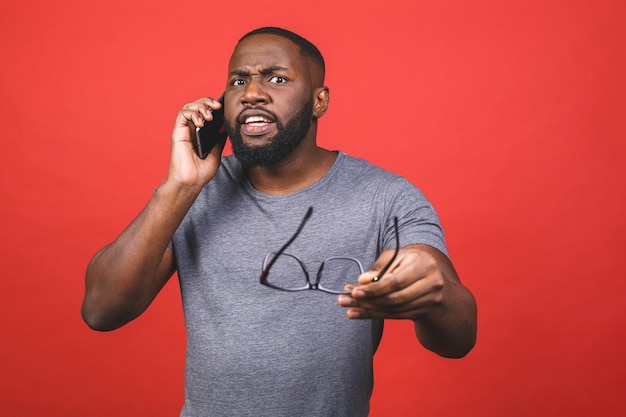 Young african american guy wearing casual holding in hands cell reading gadget device