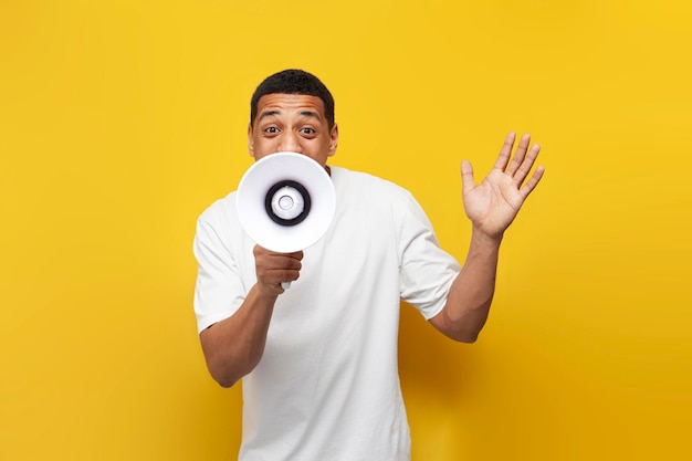 Young african american guy in white tshirt announces the news through loudspeaker