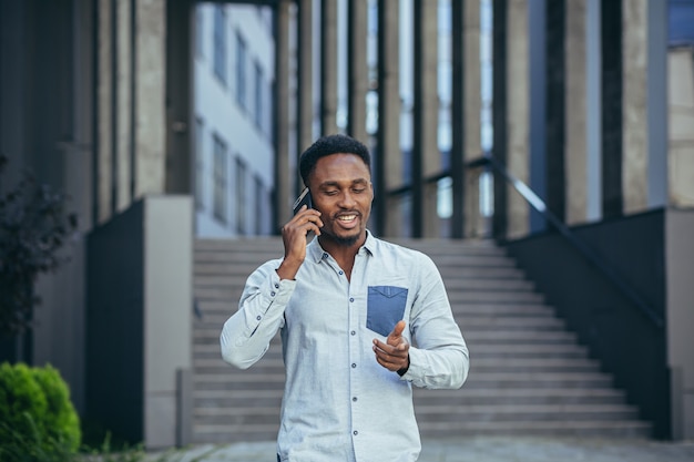 Young african american male student having fun talking on cell phone