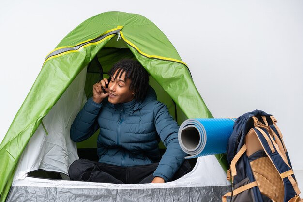 Young African American man doing camping over wall