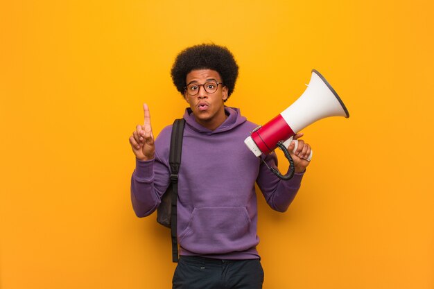 Young african american man holding a megaphone having a great idea