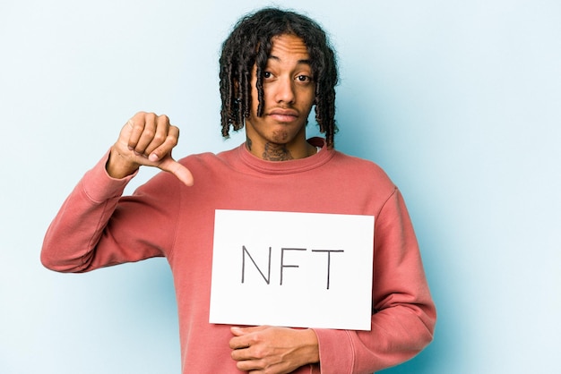 Young African american man holding NFT placard isolated on blue background feels proud and self confident example to follow