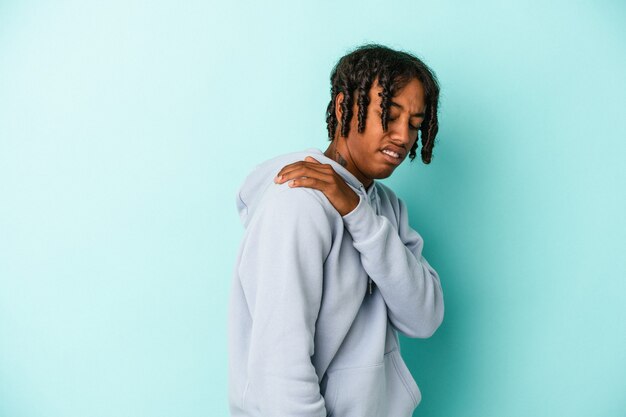 Photo young african american man isolated on blue background having a shoulder pain.