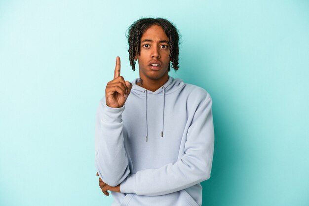 Young african american man isolated on blue background having some great idea, concept of creativity.