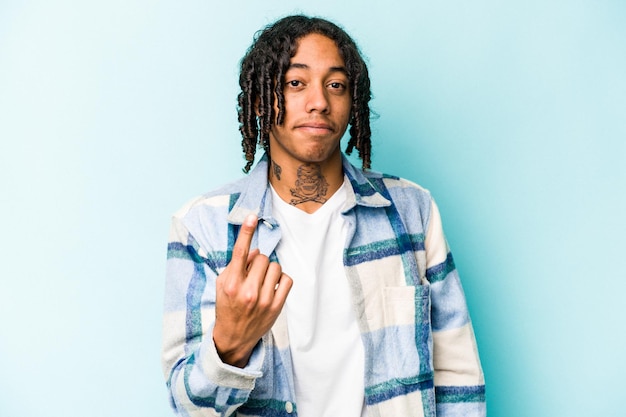 Photo young african american man isolated on blue background pointing with finger at you as if inviting come closer