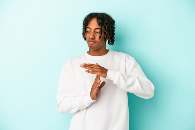 Young african american man isolated on blue background showing a timeout gesture.