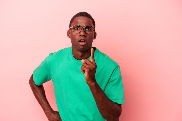 Young African American man isolated on pink background having an idea, inspiration concept.